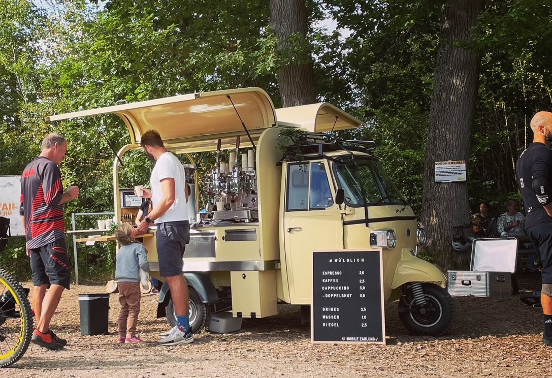 wäldlich Café-Ape im Sonnenuntergang am Wegweiser